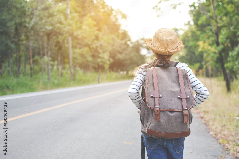 Happy Asian girl backpack in the road and forest background, Relax time on holiday concept travel ,color of vintage tone and soft focus Happy Asian girl backpack in the road and forest background, Relax time on holiday concept travel ,color of vintage tone and soft focus