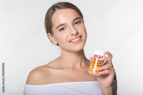 Girl is holding jar with vitamins