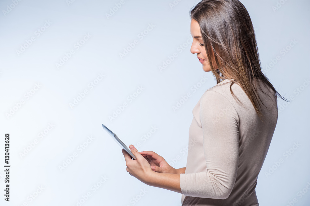 Brunette business woman working on a tablet computer to plan business meetings using the latest technology Brunette business woman working on a tablet computer to plan business meetings using the latest technology