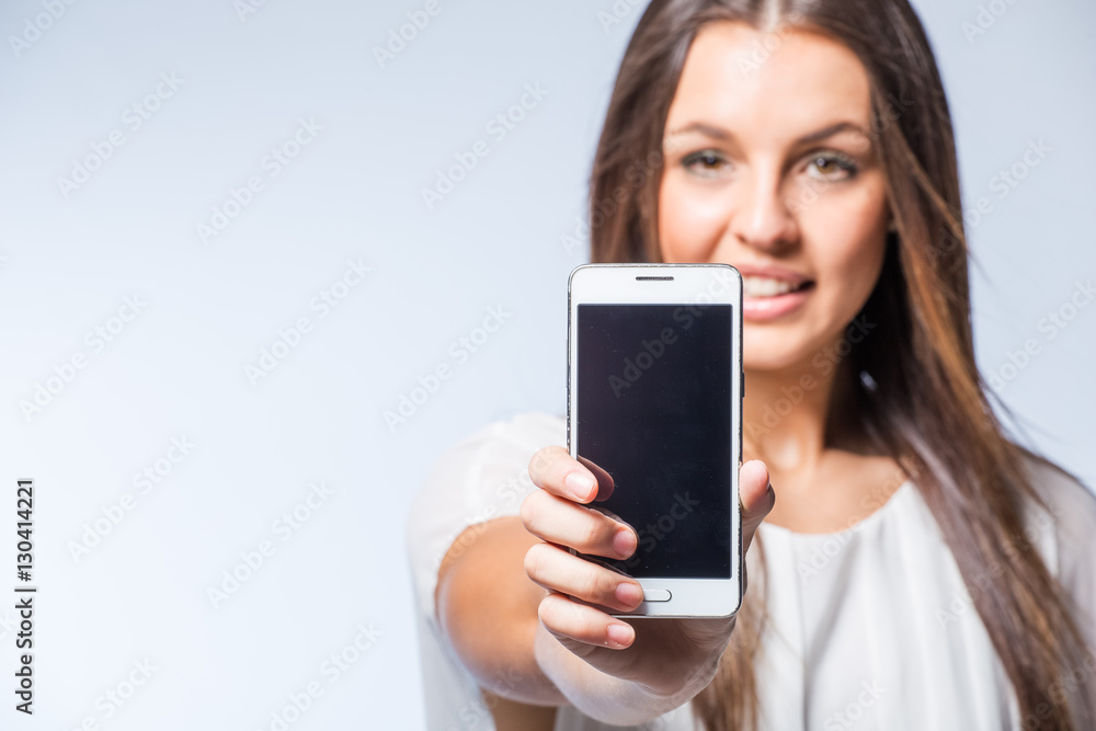 Pretty brunette business woman working on her smart phone planning business meetings or taking selfies.