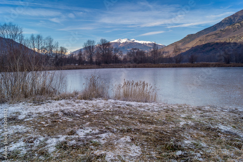 mountains, sky and clouds reflected in the lake on cold winter season