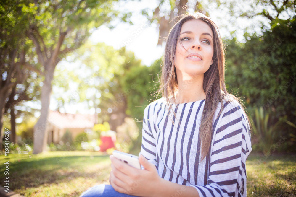 Young brunette business woman working / texting / talking / taking a selfie on her smart phone while out and about in a suburban area Young brunette business woman working / texting / talking / taking a selfie on her smart phone while out and about in a suburban area