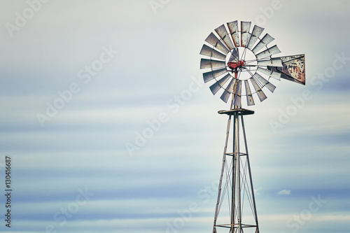 Vintage toned photo of an old western windmill tower, American wild west symbol, space for text.