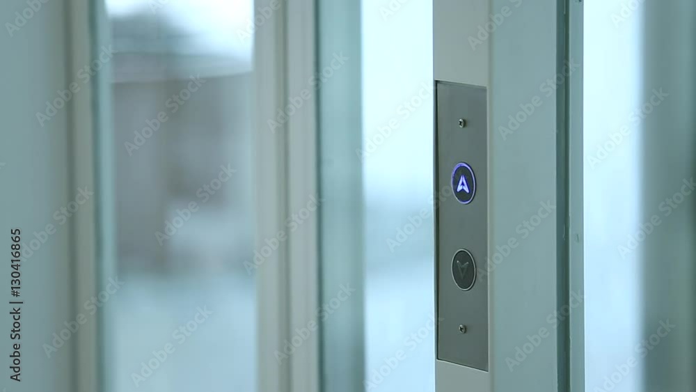 Man Pressing The Button On A Modern Glass Lift
