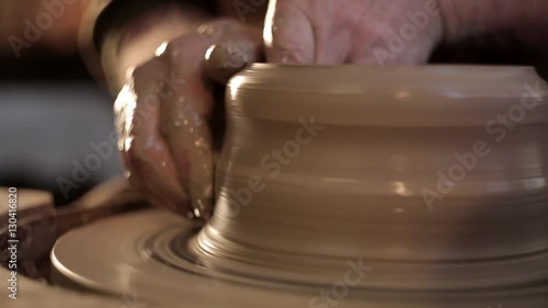 traditional pottery making, close up of potter's hands shaping a bowl on the spinning by clay