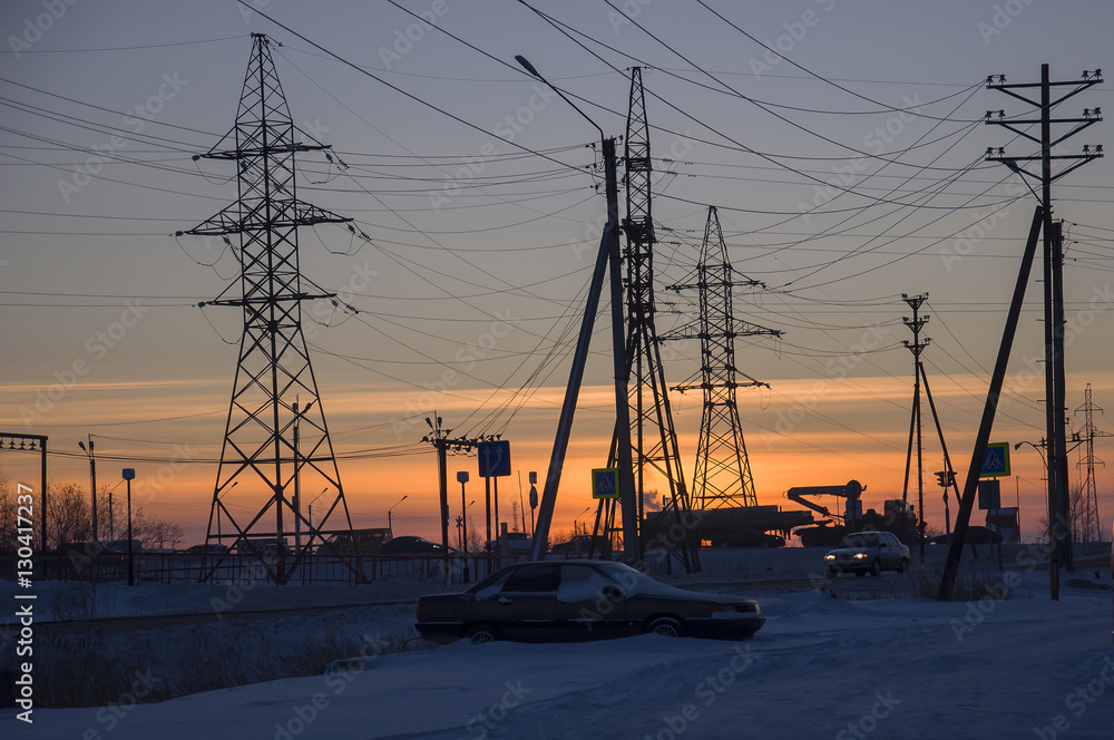 Winter bright sunset with many electric poles and wires. North. At the polar circle