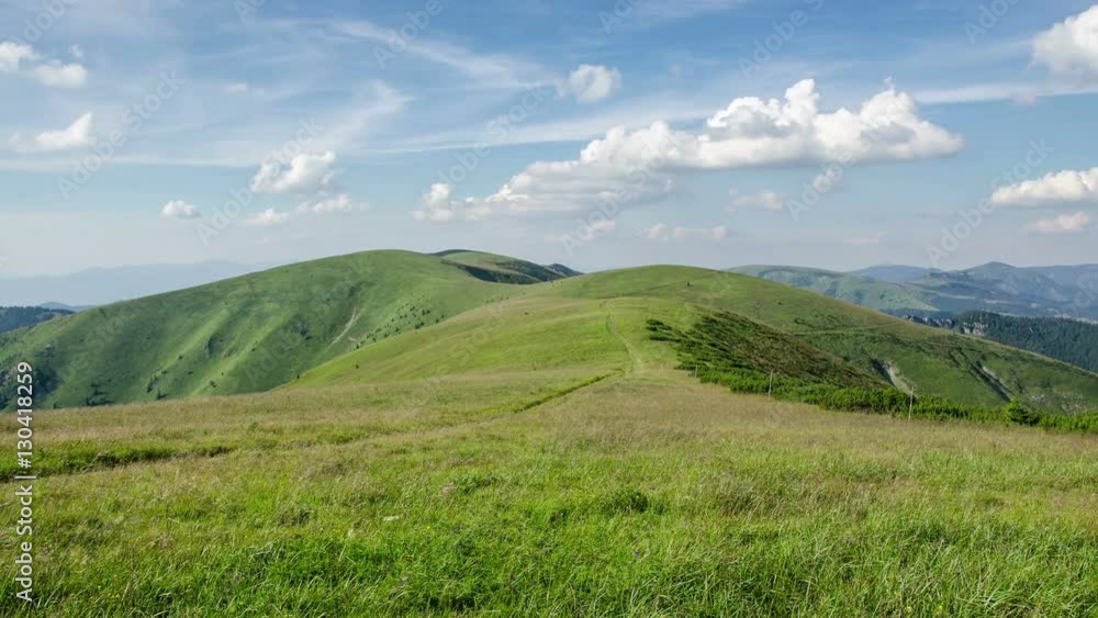 Calm sunny day in green mountain meadow with blue sky and white clouds time lapse Calm sunny day in green mountain meadow with blue sky and white clouds time lapse