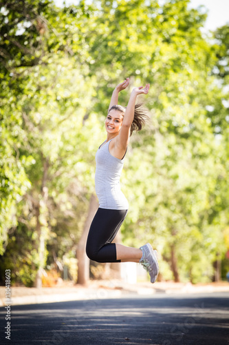 Close up image of a female fitness model running / exercising in a street in a suburban area
