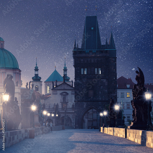 Prague, Czech Republic. Charles Bridge with its statuette at night, Old Town Bridge Tower in the background. Mystical Photo Night Prague.