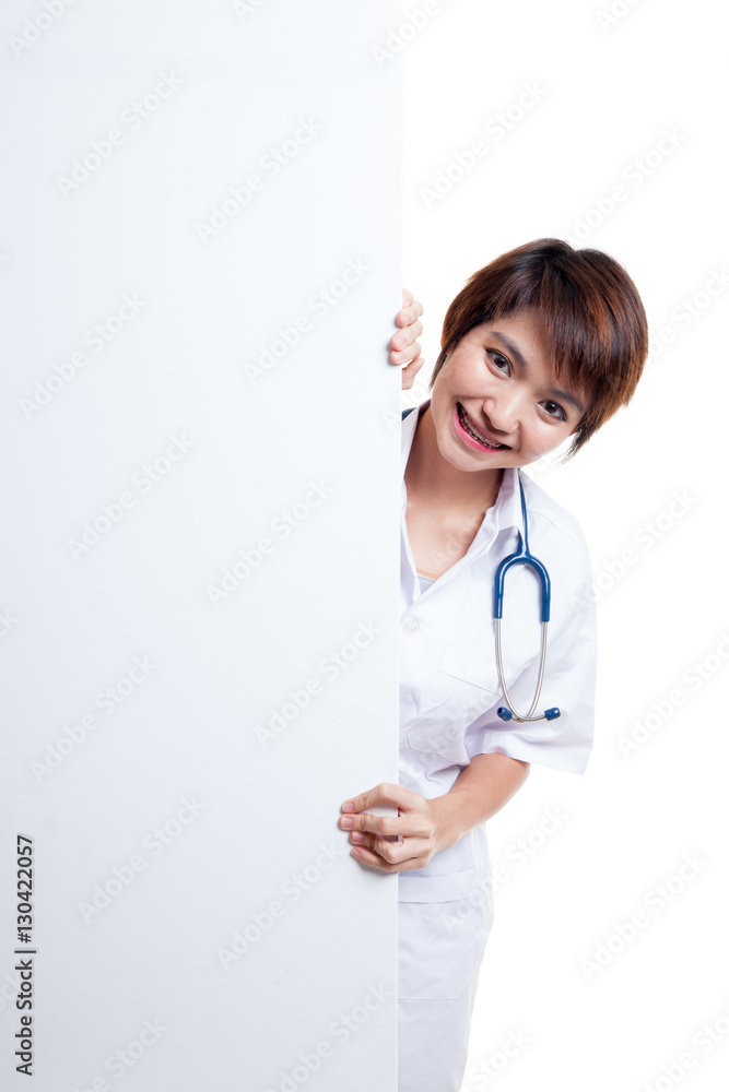 Young Asian female doctor peeking from behind blank sign billboa Young Asian female doctor peeking from behind blank sign billboa