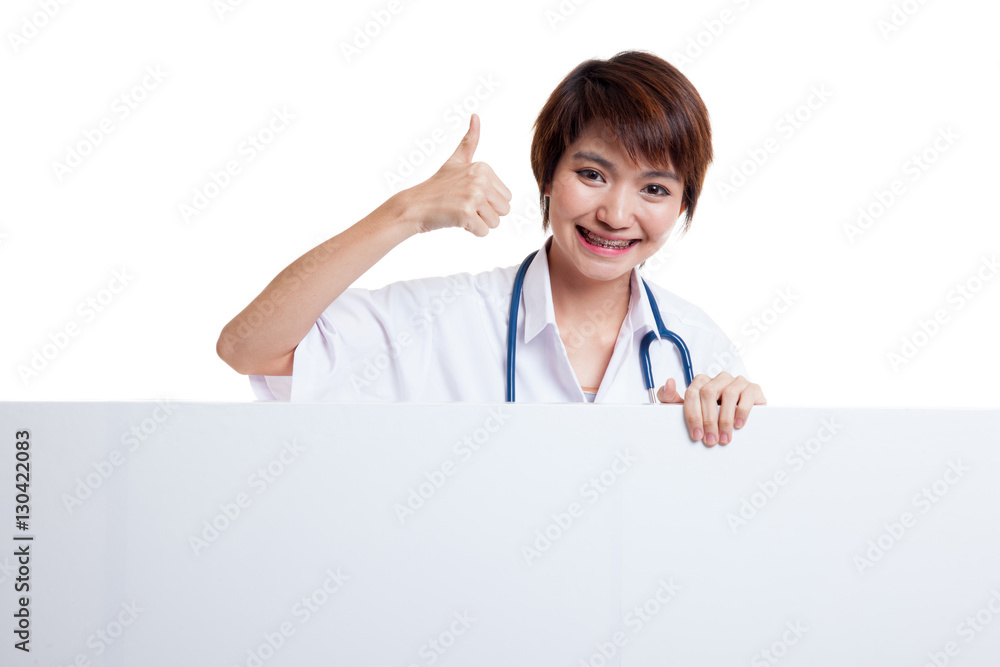 Young Asian female doctor show thumbs up behind blank white bil Young Asian female doctor show thumbs up behind blank white bil