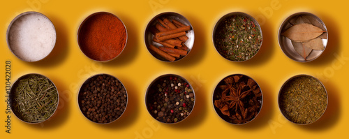 Bright set of spices Asian and South American cuisine in metal cans on yellow background