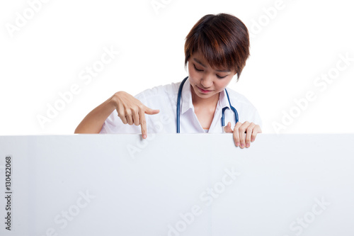 Young Asian female doctor point and look down to blank sign.
