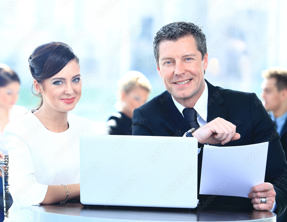 Obraz premium Businessmen and businesswoman discussing tasks sitting at office table