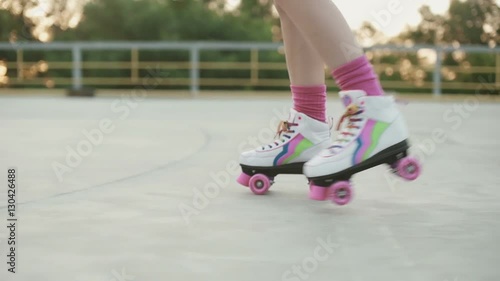 Female legs in roller blades skating at the playground