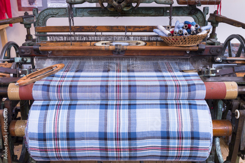 Highland tartan fabric on traditional weaving loom at Lochcarron Weavers in Lochcarron in the Highlands of Scotland photo