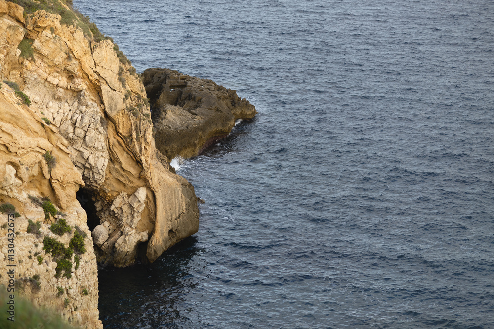 Deep blue sea waves splashing rocks Sicily coast