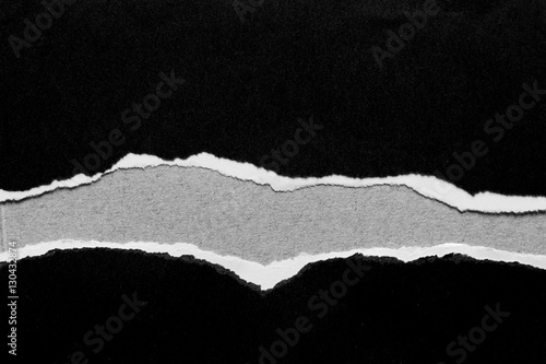 Ripped black paper on grey background
