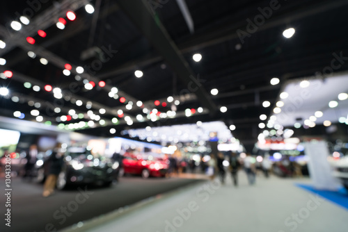 Blurred, defocused background of public event exhibition hall showing cars and automobiles, business commercial event concept photo