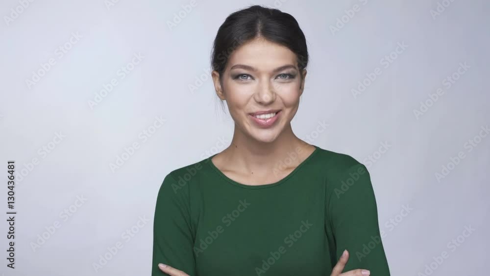 Young pensive bunette woman in green sweater looking at camera and smiling Young pensive bunette woman in green sweater looking at camera and smiling