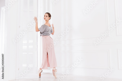 Delighted pretty ballerina posing in the studio