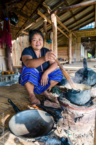 Indigenous White Karen (Kayin) hill tribe villager cooking at a traditional stove in a mountain village near Doi Inthanon, Chiang Mai