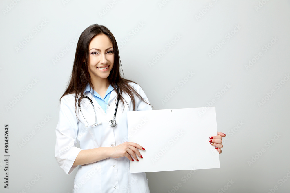 Portrait of young medical doctor with sheet on blank paper on a Portrait of young medical doctor with sheet on blank paper on a