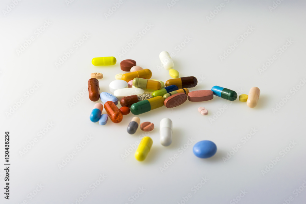 Many colored tablets and capsules isolated on white background. Many colored tablets and capsules isolated on white background.