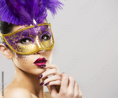 paarty woman swearing golden mask on light backgound photo