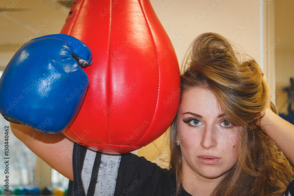 beautiful girl in boxing gloves punching bag hugs