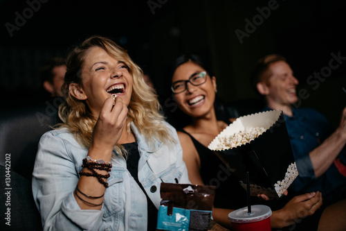 Young woman with friends watching movie