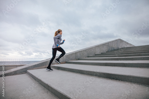 Healthy woman climbing up on stairs