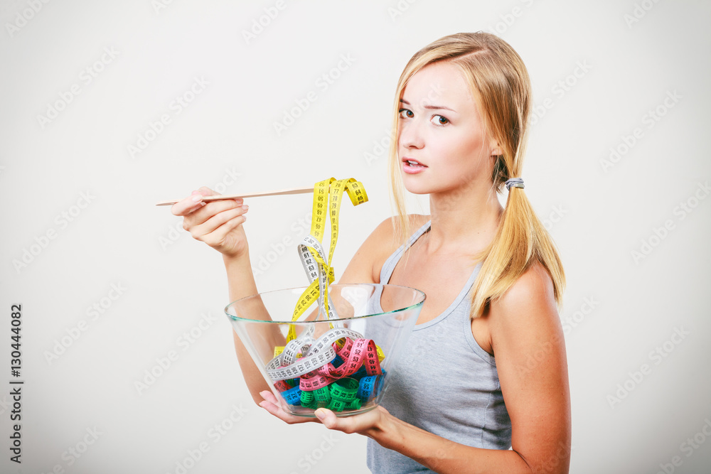 Diet. Girl with colorful measuring tapes in bowl Diet. Girl with colorful measuring tapes in bowl