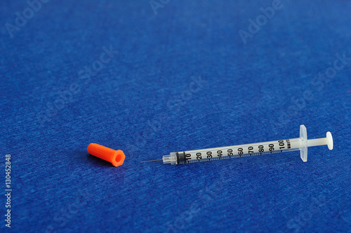 An injection isolated against a blue background
