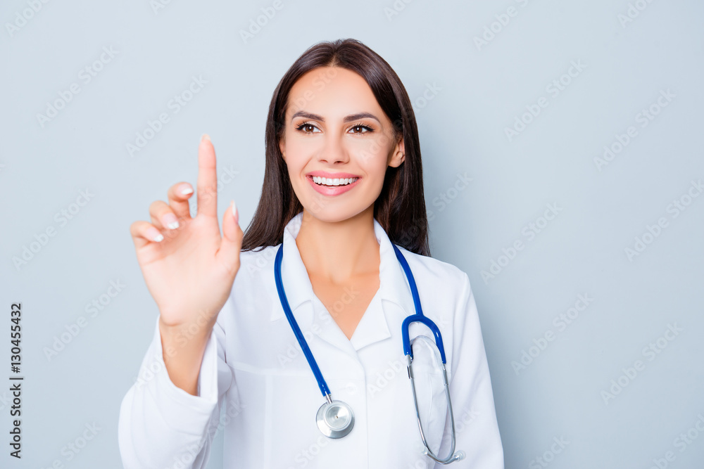Young happy female doctor touching virtual screen Young happy female doctor touching virtual screen