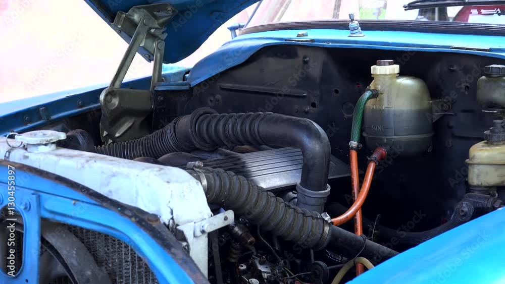 Redesigned engine under the open hood of an old american car. Havana Redesigned engine under the open hood of an old american car. Havana