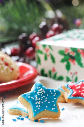 Xmas star shaped cookies with red and blue royal icing on holiday background, selective focus