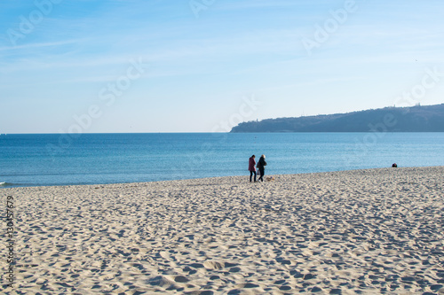 people walking at sea coast in winter