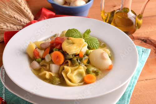 Tortellini soup with vegetables and cipollinesu table