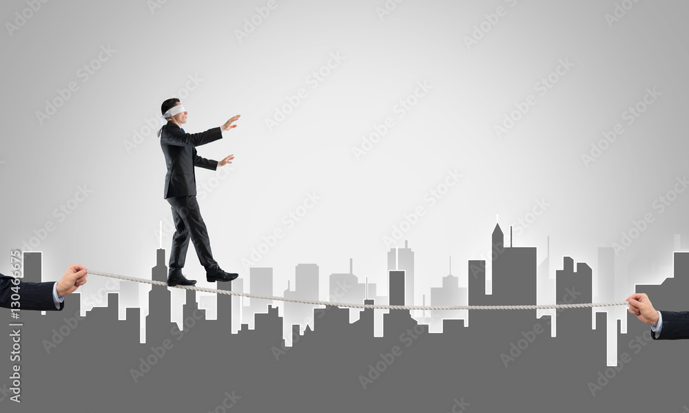 Business concept of risk support and assistance with man balancing on rope Business concept of risk support and assistance with man balancing on rope
