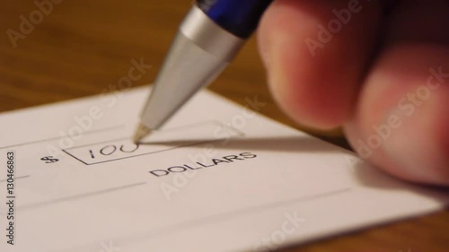 Close up check being written for one thousand dollars on table