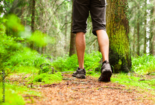 Closeup of male hiker's shoes walking through the forest. 