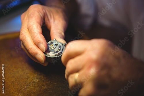 Horologist examining a clock part
