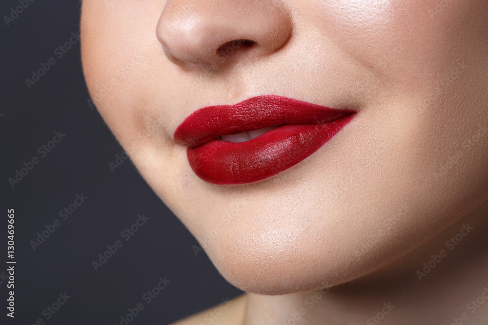 Fototapeta premium Close-up happy female smile with healthy white teeth, dark red matt lips make-up. Cosmetology, dentistry and beauty care.