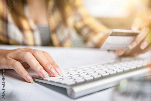 Woman shopping online Hands holding credit card and using laptop