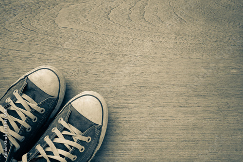 Fotografía Old worn sneakers on a background of boards..