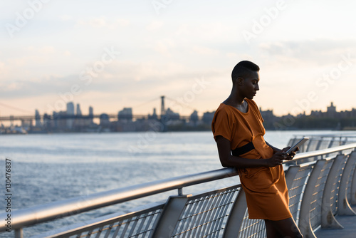 Young fashionable african woman with tablet outdoor, New York, Manhattan view, skyline