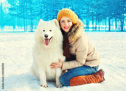 winter young smiling woman owner with white Samoyed dog © rohappy