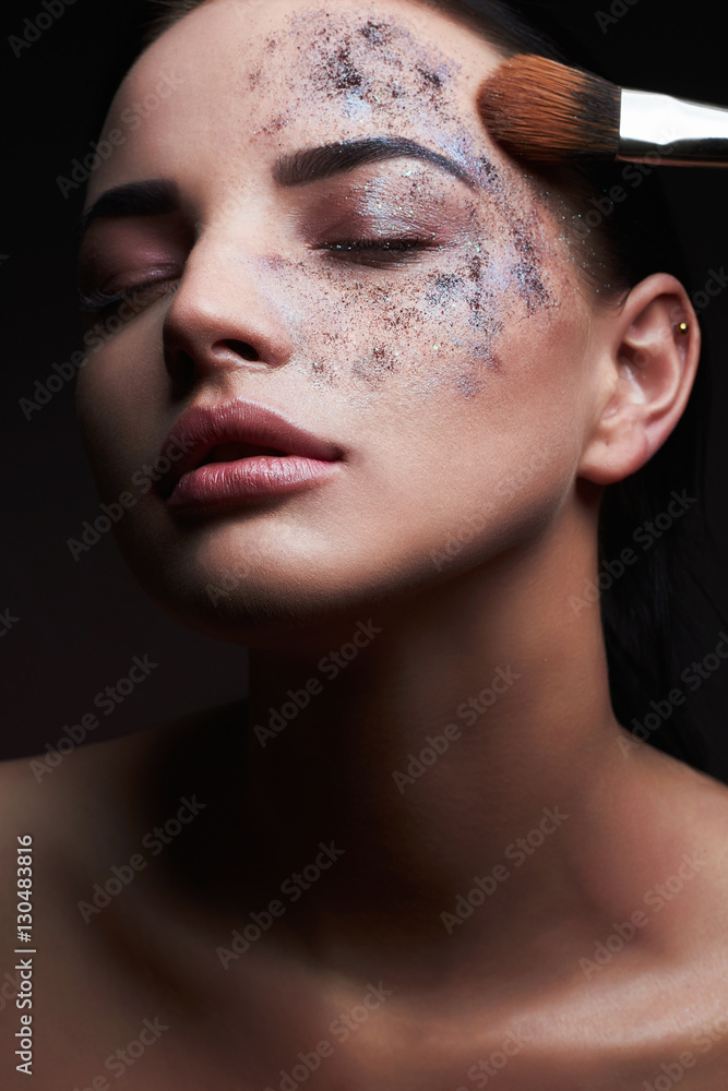 beauty and makeup.beautiful woman applying color powder on the face using makeup brush