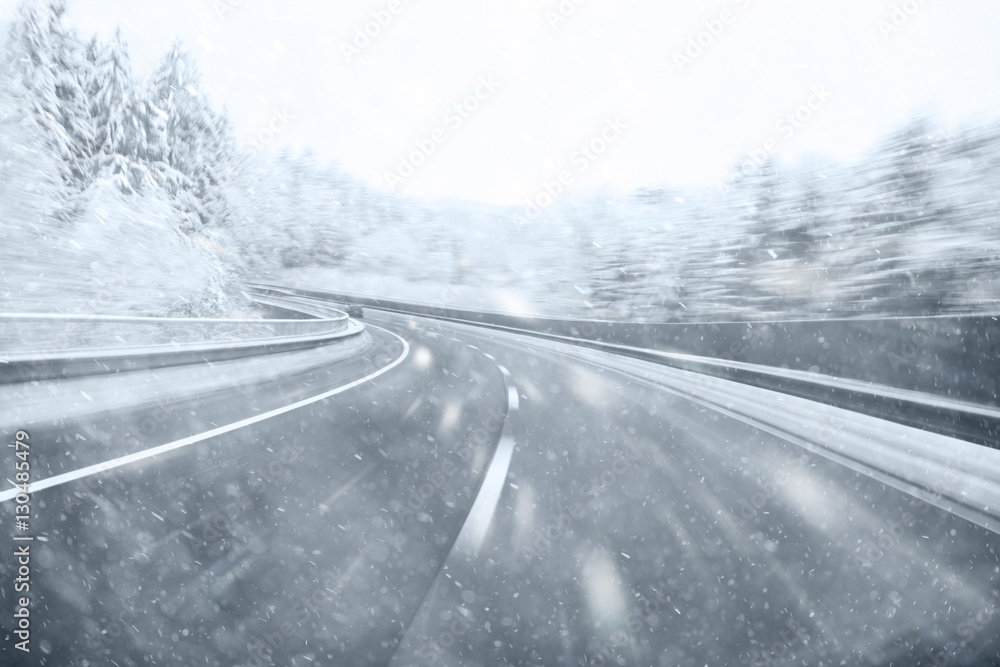 Dangerous winter season car driving on slippery highway. Heavy snowfall conditions on the highway. Dangerous winter season car driving on slippery highway. Heavy snowfall conditions on the highway.